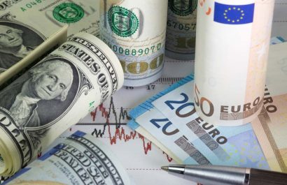 Rolled Us dollar bills and euro bills lying on the chart of dollar euro prices.Black and red lines on the diagram. Pen on the graph. Concept of currencies trading. Twenty, fifty euros .