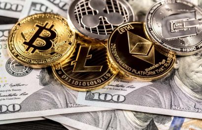 Silver and golden coins with bitcoin, ripple and ethereum symbol on wood background.